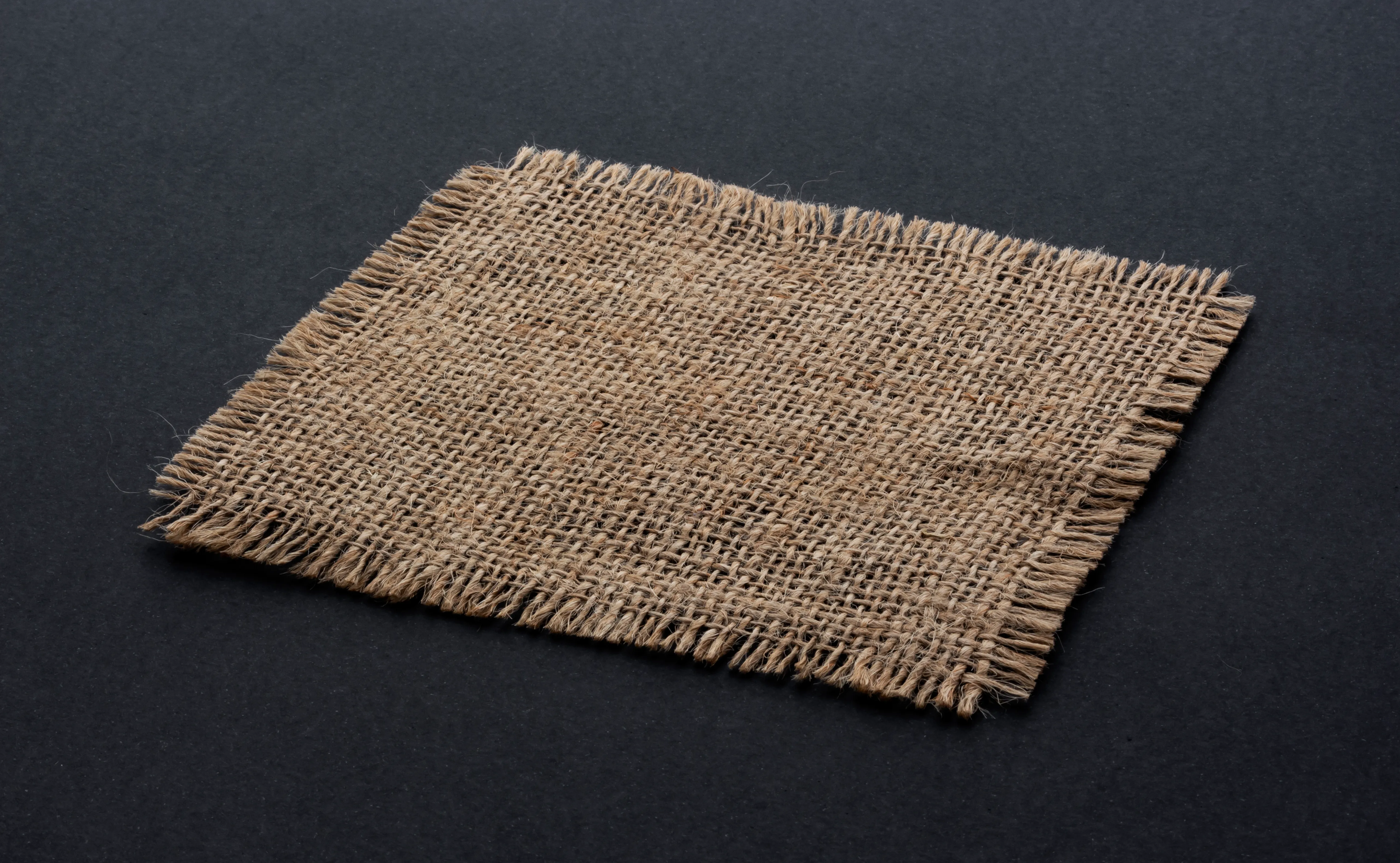 Old burlap fabric napkin on black background